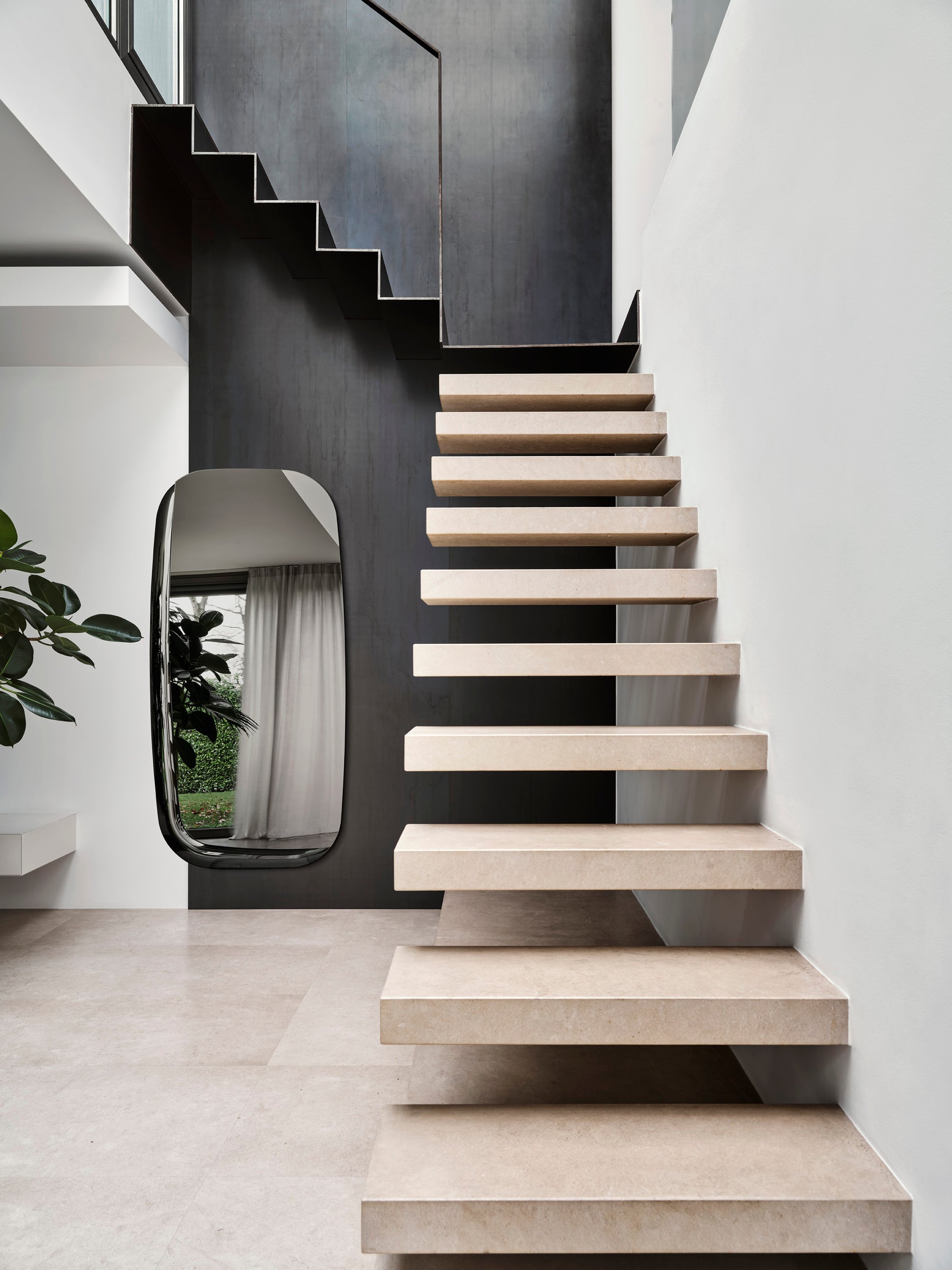 Calligaris speil i sotet glass med dekorativ buet speilflate